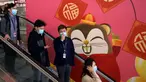 Orang-orang memakai masker saat menaiki eskalator di Bandara Internasional Hong Kong di Hong Kong, Selasa (21/1/2020). Masker terjual habis dan pemeriksaan suhu di bandara dan stasiun kereta api menjadi norma baru di China menyusul merebaknya wabah virus corona.  (AP/Ng Han Guan)