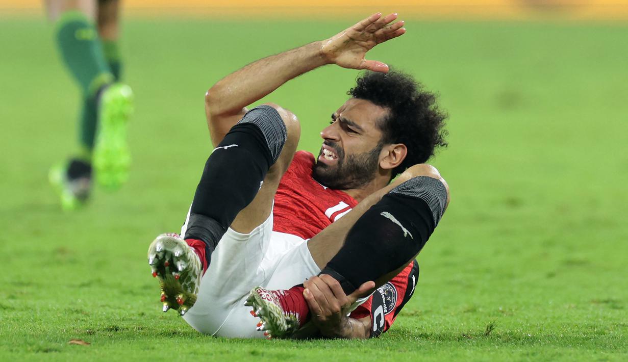 Striker Mesir, Mohamed Salah mengerang kesakitan usai dijatuhkan pemain Senegal dalam laga final Piala Afrika 2021 di Stade d'Olembe, Yaounde, Kamerun (6/2/2022). (AFP/Kenzo Tribouillard)