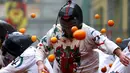 Peserta ikut ambil bagian dalam perang-perangan dengan jeruk selama karnaval di kota Ivrea, Italia, Minggu (7/2). Peserta yang dibagi menjadi dua tim ini saling melempar jeruk menggunakan kostum dan aksesoris lengkap. (REUTERS/Stefano Rellandini)
