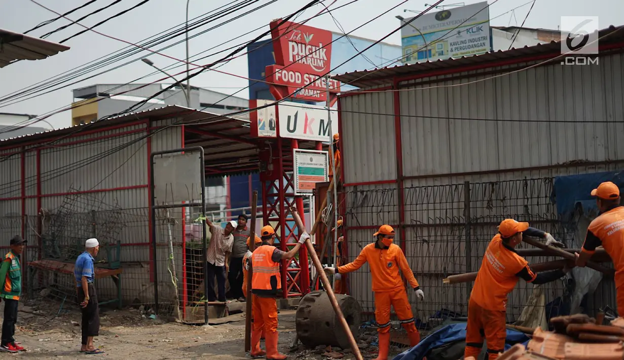 Petugas PPSU membongkar bangunan kios pedagang nasi kapau di Jalan Kramat Raya, Senen, Jakarta, Jumat (6/9/2019). Pembongkaran disebabkan adanya rencana revitalisasi trotoar di jalan tersebut. (Liputan6.com/Immanuel Antonius)