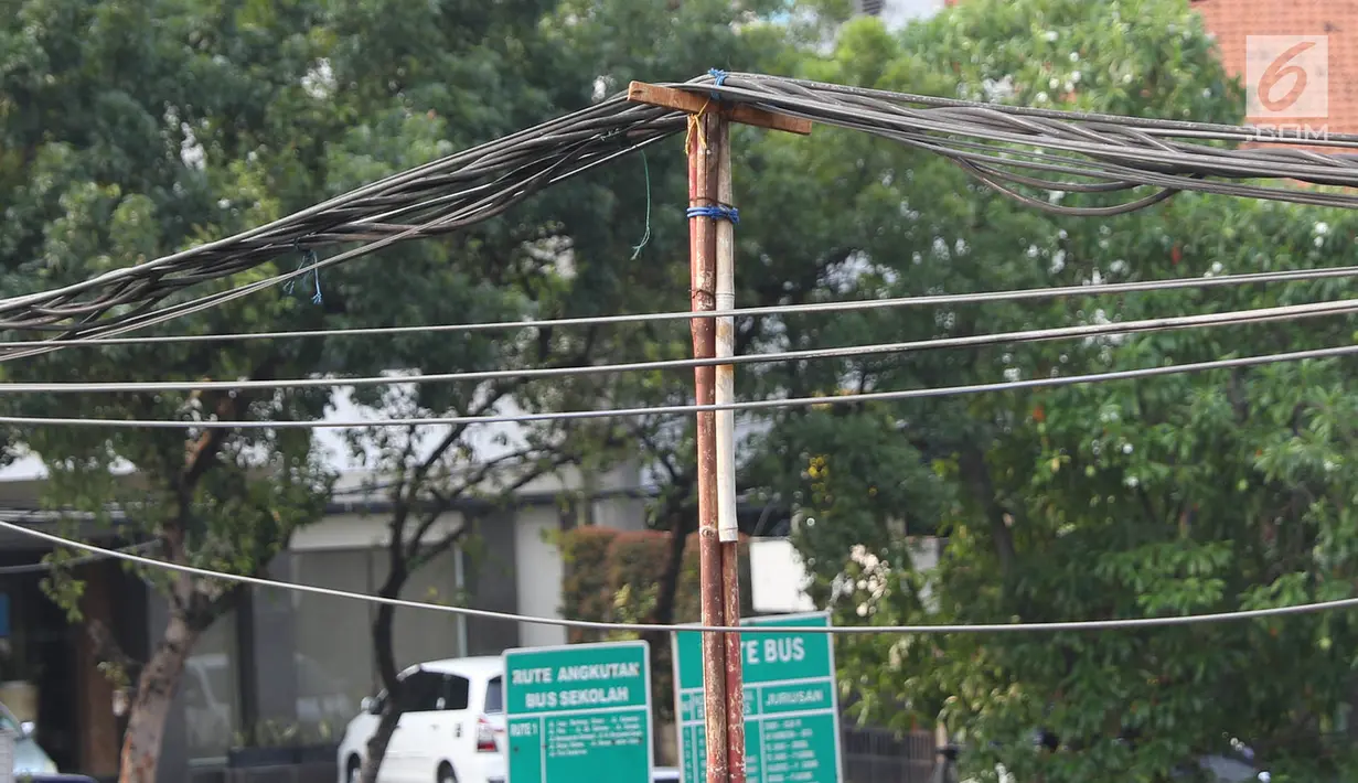 Tiang bambu menyangga instalasi kabel di kawasan Pasar Baru, Jakarta, Selasa (12/9). Selain membahayakan pengguna jalan, buruknya instalasi kabel tersebut juga merusak estetika kota. (Liputan6.com/Immanuel Antonius)