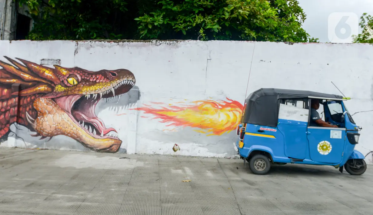 Bajaj melintasi depan kreasi mural di sepanjang dinding bantaran Kali Opak, Jakarta Utara, Kamis (6/2/2020). Tembok bangunan saat ini tak hanya menjadi pembatas semata tapi dimanfaatkan untuk menyampaikan pesan-pesan dan harapan dalam bentuk goresan atau tulisan-tulisan. (merdeka.com/Imam Buhori)