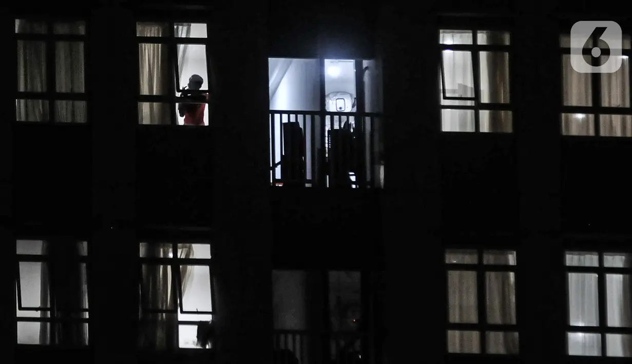 Pasien COVID-19 terlihat pada jendela salah satu kamar isolasi Rumah Sakit Darurat Wisma Atlet Kemayoran, Jakarta, Selasa (19/1/2021). Pemprov DKI Jakarta mengungkapkan ketersediaan tempat tidur isolasi dan ICU di rumah sakit rujukan COVID-19 tersisa 13 persen. (merdeka.com/Iqbal S. Nugroho)