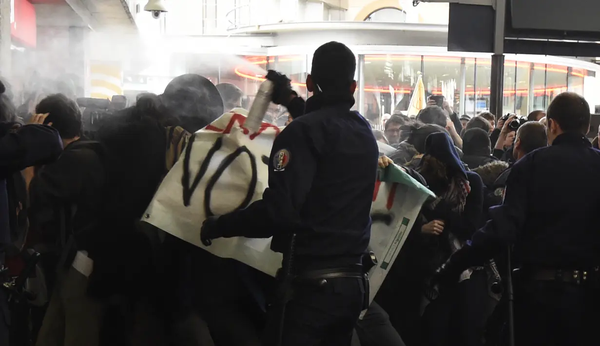 Polisi menyemprot gas air mata saat aksi di Perancis berujung ricuh, Selasa (12/4). Demonstran menentang reformasi hukum perburuhan yang dirancang pemerintah Perancis. (AFP Photo/ Dominique Faget)