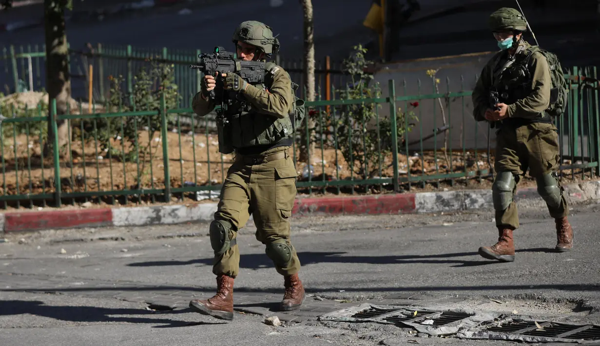 Seorang tentara Israel membidikkan senapannya ke arah demonstran Palestina saat terjadi bentrokan usai aksi demonstrasi menolak rencana aneksasi Israel di Kota Hebron, Tepi Barat, Jumat (3/7/2020). (Xinhua/Mamoun Wazwaz)