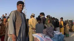 Seorang pria Afghanistan bersiap untuk mendorong gerobak dorong dengan barang-barang makanan yang didistribusikan oleh organisasi Kristen yang berbasis di Islamabad di pinggiran Chaman, sebuah kota perbatasan di provinsi Baluchistan barat daya Pakistan, Selasa (31/8/2021). (AP Photo)