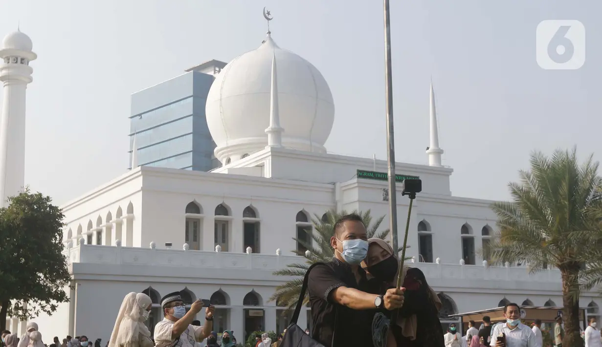 Umat muslim berswafoto usai melaksanakan shalat Idul Fitri 1442 H di Lapangan Masjid Agung Al Azhar, Jakarta, Kamis (13/5/2021). Ribuan umat muslim melaksanakan shalat Idul Fitri 1442 H di Lapangan Masjid Agung Al Azhar dengan menerapkan protokol kesehatan ketat. (Liputan6..com/Helmi Fithriansyah)