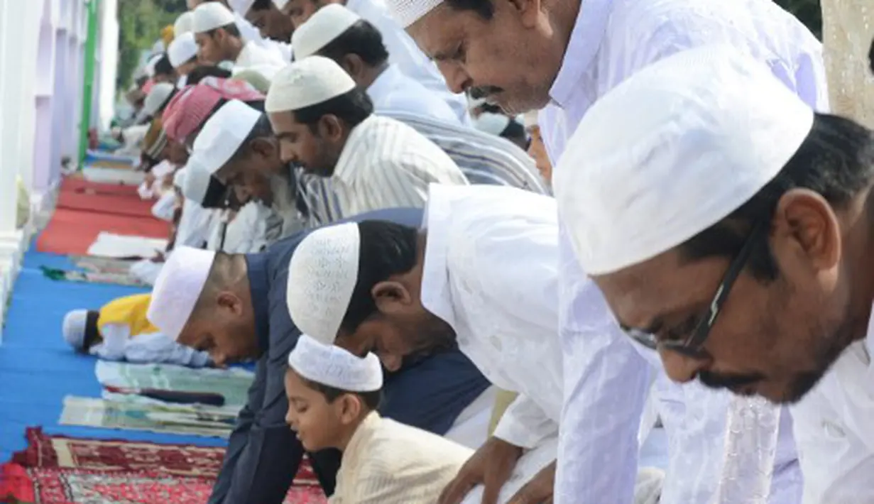 Bocah yang belum dewasa memang belum diwajibkan untuk salat. Para orang tua sengaja membawa anaknya salat berjamaah agar terbiasa nantinya, Hyderabad, India, Senin (6/10/2014) (AFP Photo/Noah SEELAM) 