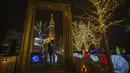 Sepasang kekasih berpose dengan latar belakang gedung balai kota di pasar Natal di Wina, Austria, Minggu (21/11/2021). Pemerintah Austria mengumumkan penguncian nasional yang akan dimulai Senin (22/11). (AP Photo/Vadim Ghirda)