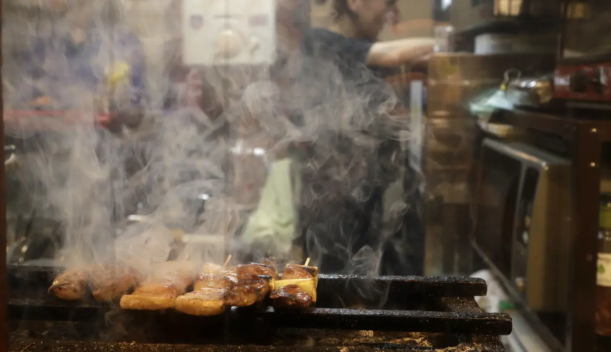 Yakitori saat dibakar di sebuah bar di area jalan malam belakang pusat kota Tokyo (4/10/2019). Yakitori merupakan sate khas dari Jepang yang umumnya menggunakan daging ayam.  (AP Photo/Mark Baker)