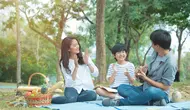 Sebuah keluarga kecil yang terdiri dari ayah, ibu, dan seorang anak laki-laki sedang mengadakan piknik di taman (Foto Dok: Freepik/mkitina4).