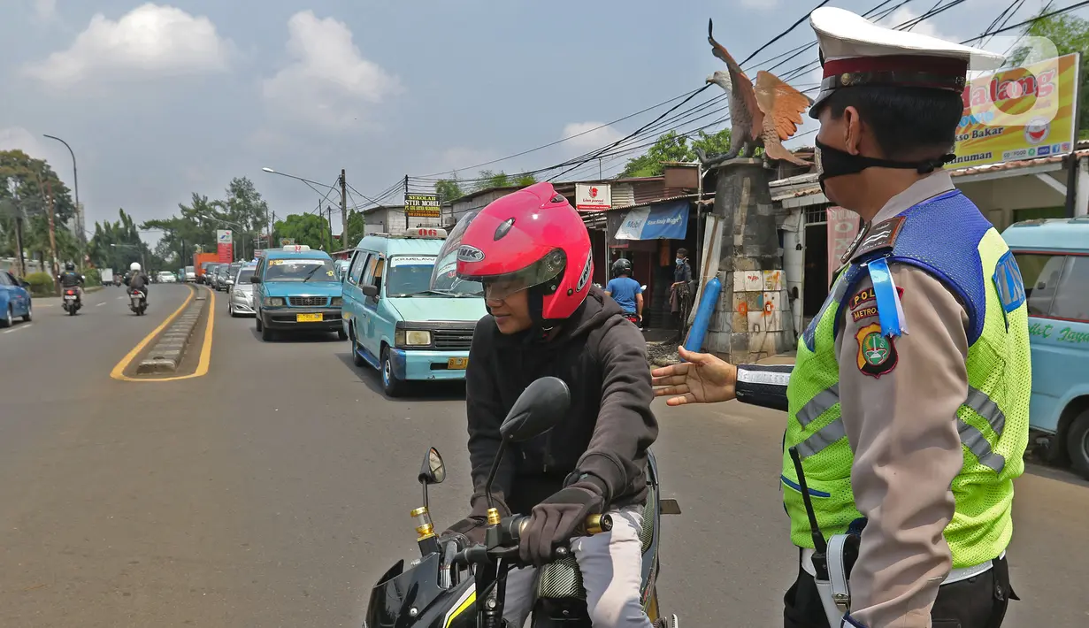 Polisi lalu lintas melaksanakan pengawasan dalam penerapan Pembatasan Sosial Bersekala Besar (PSBB) di jalan perbatasan Depok-Jakarta, Jumat (10/4/2020). Petugas menyetop kendaraan untuk menghimbau kewajiban memakai masker dan aturan penumpang dalam satu kendaraan.  (Liputan6.com/Herman Zakharia)