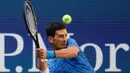 Petenis Serbia, Novak Djokovic  memukul bola ke arah lawannya Roberto Carballes Baena dari Spanyol pada  babak pertama AS Terbuka 2019 di Billie Jean King National Tennis Center, New York, Senin (26/8/2019). Peringkat satu dunia itu menang 6-4, 6-1, dan 6-4. (AP/Frank Franklin II)