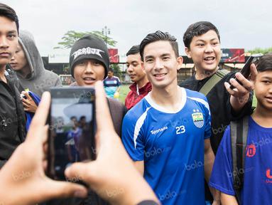 Gelandang Persib, Kim Jeffrey Kurniawan, dengan ramah melayani permintaan para Bobotoh yang memintanya foto bareng usai latihan di Lapangan Progresif, Bandung, Senin (2/5/2016). (Bola.com/Vitalis Yogi Trisna)