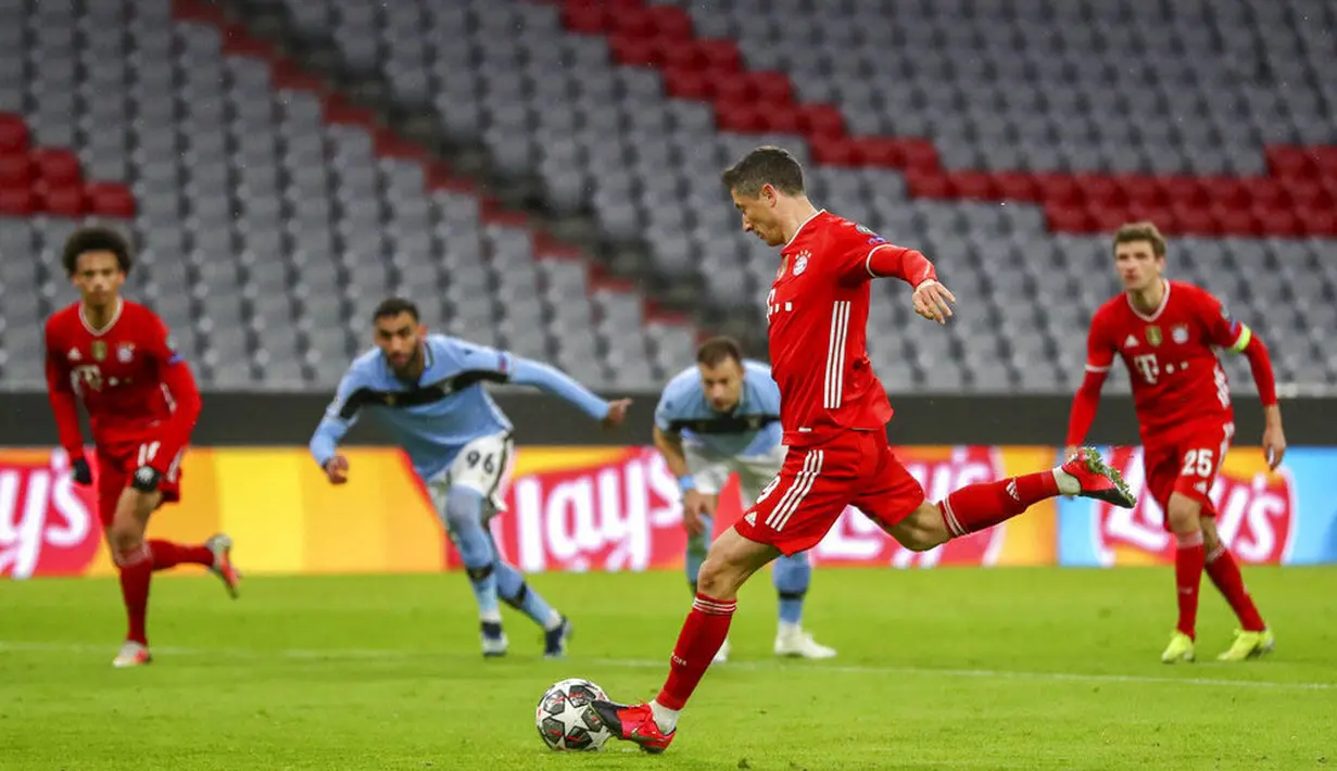 Striker Bayern Munchen, Robert Lewandowski, melepaskan tendangan penalti ke gawang Lazio pada laga Liga Champions di Allianz Arena, Kamis (18/3/2021). Bayern Munchen menang dengan skor 2-1. (AP Photo/Matthias Schrader)