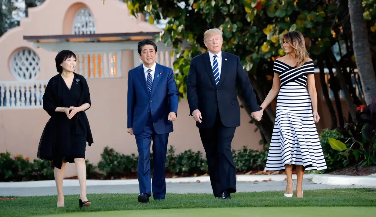 Presiden AS, Donald Trump didampingi Ibu Negara, Melania Trump berjalan bersama Perdana Menteri Jepang, Shinzo Abe dan istrinya Akie Abe untuk jamuan makan malam dalam pertemuan di Resor Mar-a-Lago, Florida, Selasa (17/4). (AP/Pablo Martinez Monsivais)
