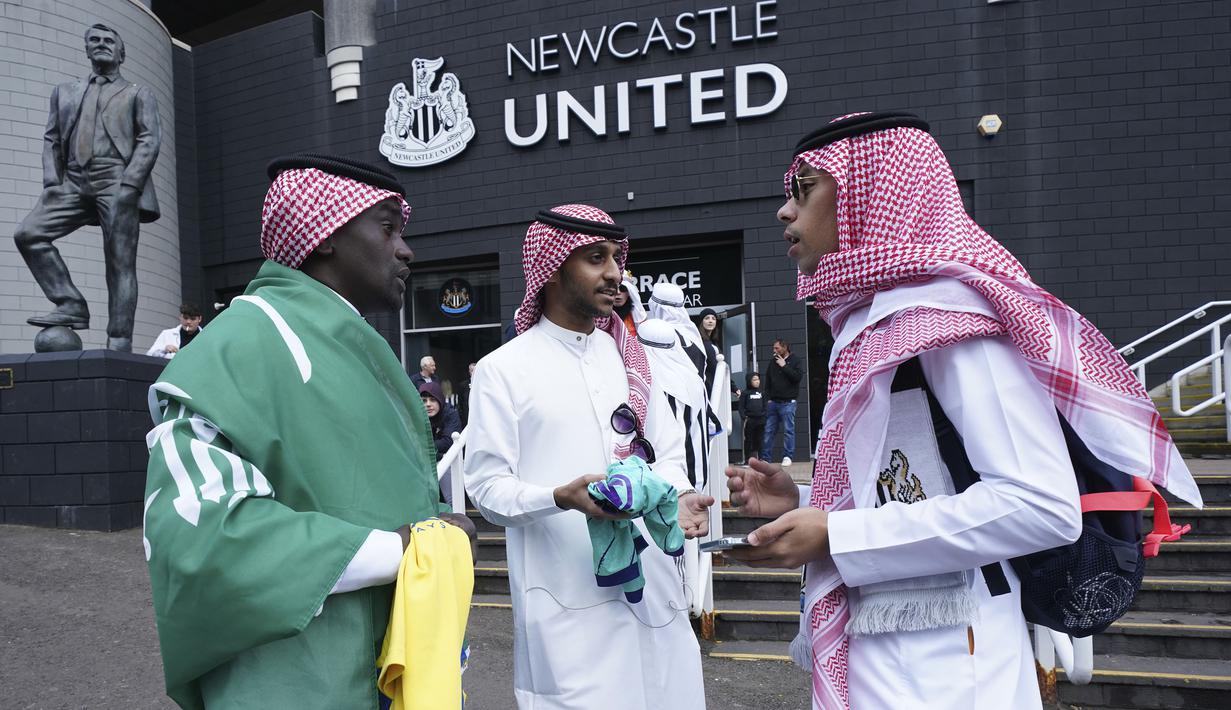 Tiga pria dari Arab Saudi berbicara di luar lapangan sebelum pertandingan sepak bola Liga Premier Inggris antara Newcastle dan Tottenham Hotspur di St. James' Park di Newcastle, Inggris, Minggu 17 Oktober 2021. (AP/Jon Super)