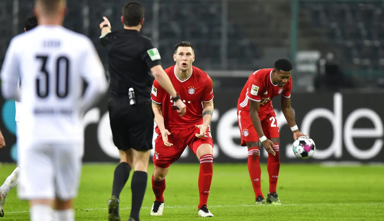 Wasit Harm Osmers memberikan pelanggaran terhadap pemain Bayern Munchen Niklas Suele (tengah) saat melawan Borussia Moenchengladbach pada pertandingan Bundesliga di Borussia Park, Moenchengladbach, Jerman, Jumat (8/1/2021). Bayern Munchen kalah 2-3. (AP Photo/Martin Meissner, Pool)