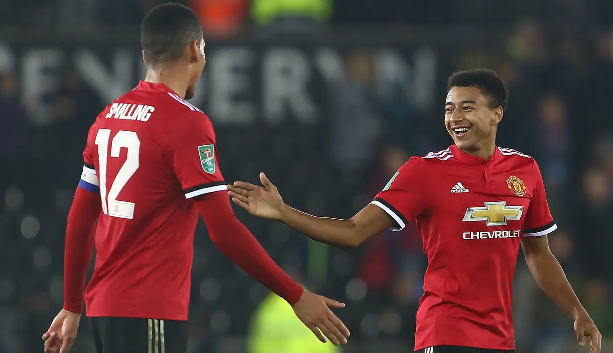 Pemain Manchester United, Chris Smalling dan Jesse Lingard bereaksi usai pertandingan Piala Liga Inggris melawan Swansea City di Liberty Stadium, Rabu (25/10). MU melaju ke perempat final setelah sukses meraih kemenangan 2-0 . (GEOFF CADDICK/AFP)