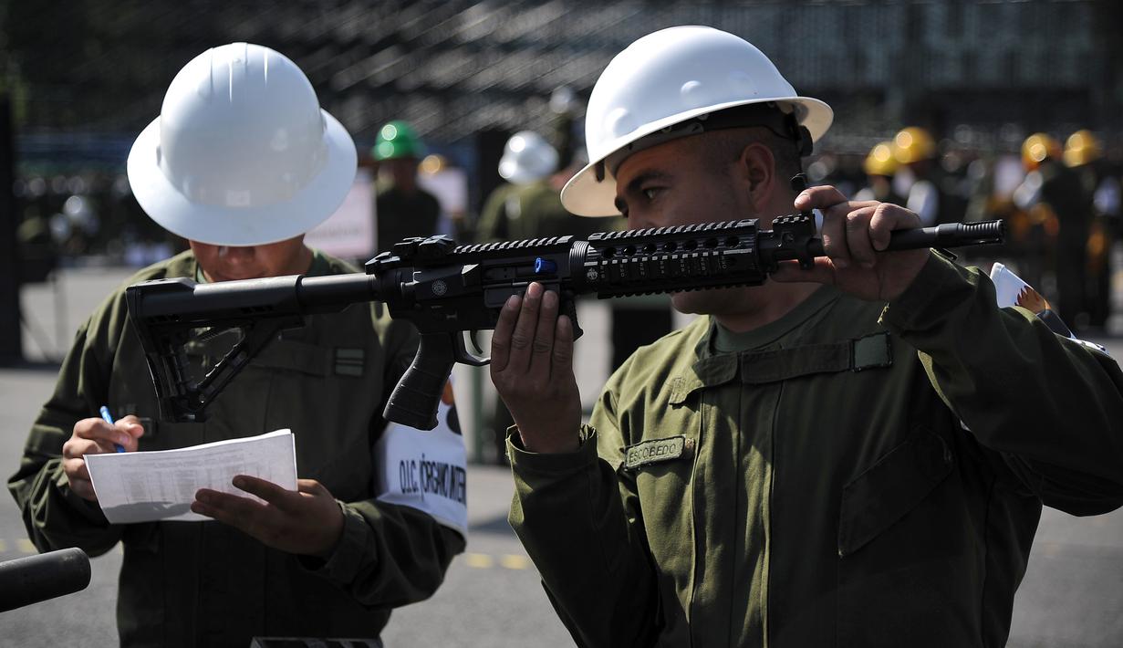 Tentara mencatat nomor seri dan model senjata otomatis selama penghancuran senjata api yang disita dari penjahat atau diserahkan oleh orang-orang, di Kamp Militer 1-A di Kota Meksiko, (1/8). (AFP Photo/Bernardo Montoya)