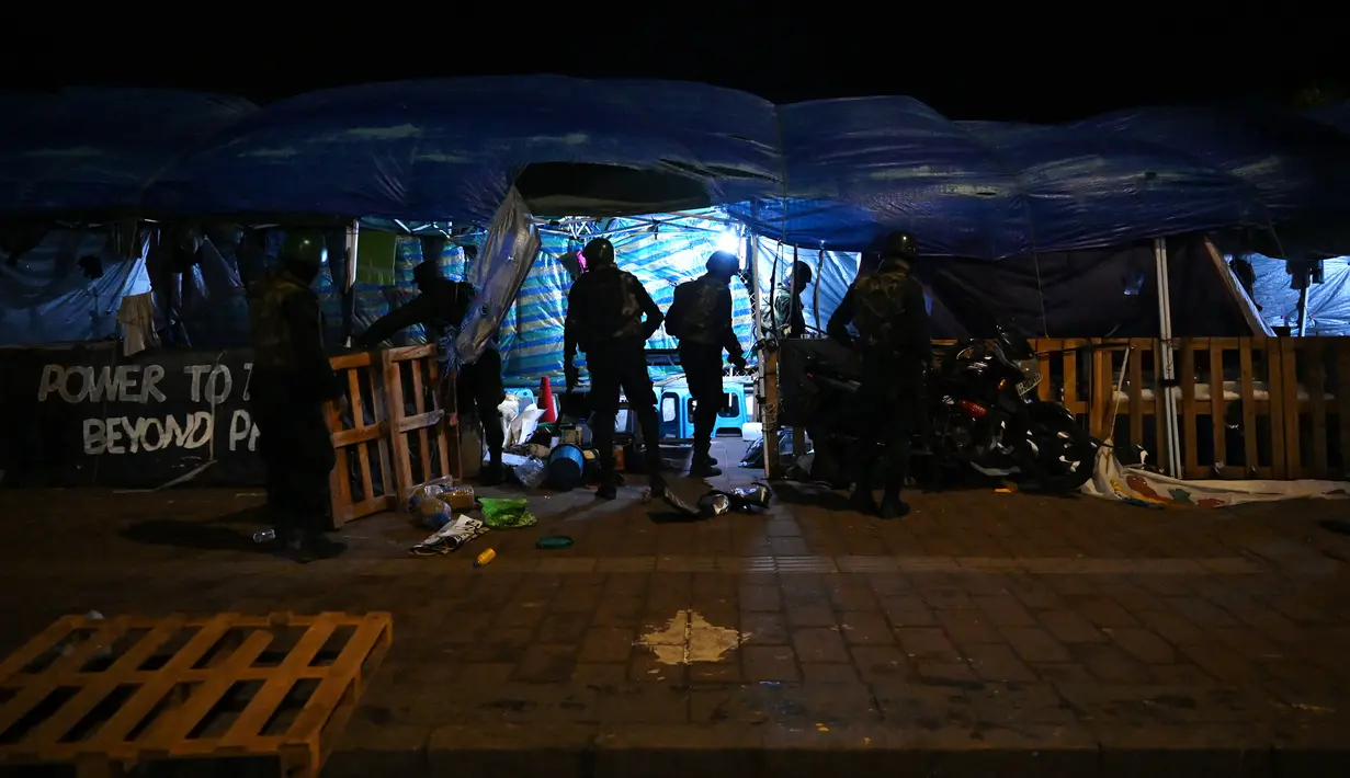 Anggota pasukan keamanan Sri Lanka membongkar bangunan sementara yang didirikan oleh pengunjuk rasa anti-pemerintah di lokasi kamp protes di depan Sekretariat Presiden di Kolombo, Jumat (22/7/2022). Ratusan tentara dan polisi Sri Lanka menggerebek kamp protes anti-pemerintah di ibu kota dan merobohkan tenda-tenda para aktivis yang tidak bersenjata. (Arun SANKAR / AFP)