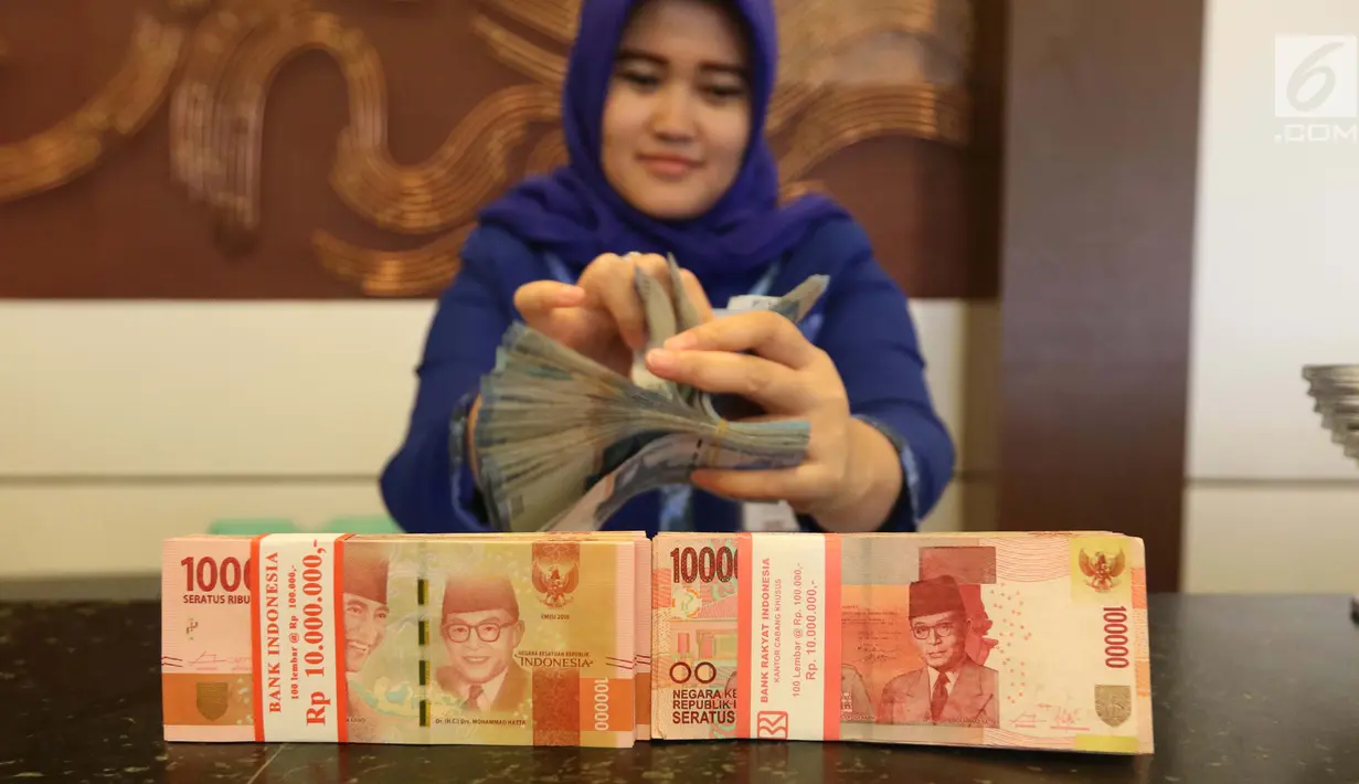 Petugas menunjukkan uang kertas rupiah di Bank BUMN, Jakarta, Selasa (17/4). Rupiah siang ini melemah dibandingkan tadi pukul 09.00 WIB di level Rp 13.771 per dolar AS. (Liputan6.com/Angga Yuniar)