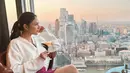 Di lain kesempatan, Jessica Mila tampak berfoto dengan gedung-gedung pencakar langit yang luar biasa. Ia mengenakan sweater putih, dipadu dengan mini pants berwarna ungu. Foto: Instagram.
