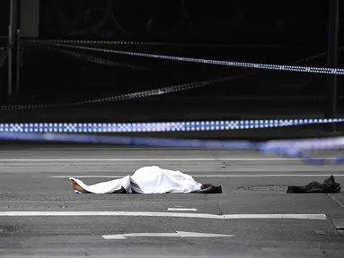 Sesosok jasad terbungkus kain putih terlihat setelah insiden penikaman di Melbourne, Australia, Jumat (9/11). Penikaman terhadap pejalan kaki tersebut diduga dilakukan oleh anggota teroris. (WILLIAM BARAT/AFP)