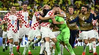 Kiper Timnas Kroasia, Dominik Livakovic bersama rekan-rekannya merayakan kemenangan atas Brasil lewat adu penalti dalam babak perempatfinal Piala Dunia 2022 di Education City Stadium, Al Rayyan, Qatar, Jumat (9/12/2022) malam WIB. (AFP/Jewel Samad)