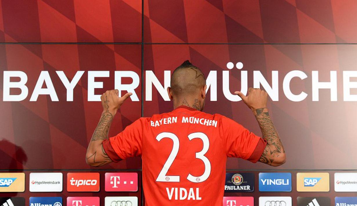 Pemain baru Bayern Munchen Arturo Vidal menunjukan kostum tim barunya dengan nomor punggung 23 saat jumpa pers di Munich, Jerman, Selasa (28/7/2015). (AFP Photo/Christof Stache)
