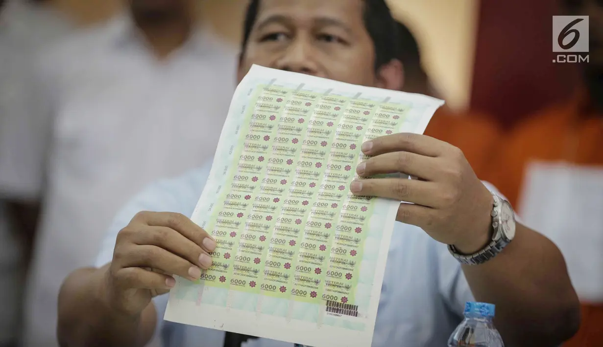 Petugas menunjukkan barang bukti materai palsu saat rilis di Polda Metro Jaya, Jakarta, Rabu (20/3). Polisi menyita 30 lembar materai palsu 6000 siap edar dengan isi 50 keping per lembar. (Liputan6.com/Faizal Fanani)