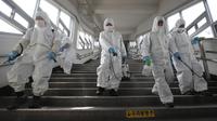 Pekerja memakai alat pelindung semprotan disinfektan untuk membantu mencegah penyebaran Virus Corona COVID-19, di stasiun kereta bawah tanah di Seoul pada 12 Maret 2020. (YONHAP / AFP)