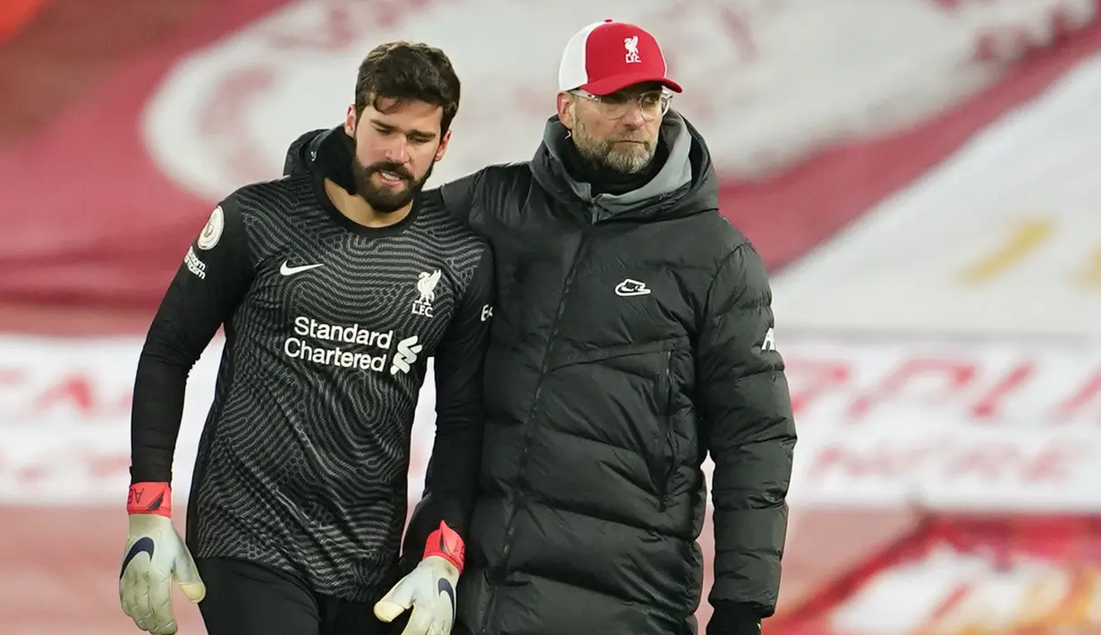 Kiper Liverpool, Alisson Becker (kiri) dihibur manajer tim, Jurgen Klopp usai dikalahkan Burnley 0-1 dalam laga lanjutan Liga Inggris 2020/21 di Anfield Stadium, Kamis (21/1/2021). (AFP/Jon Super/Pool)