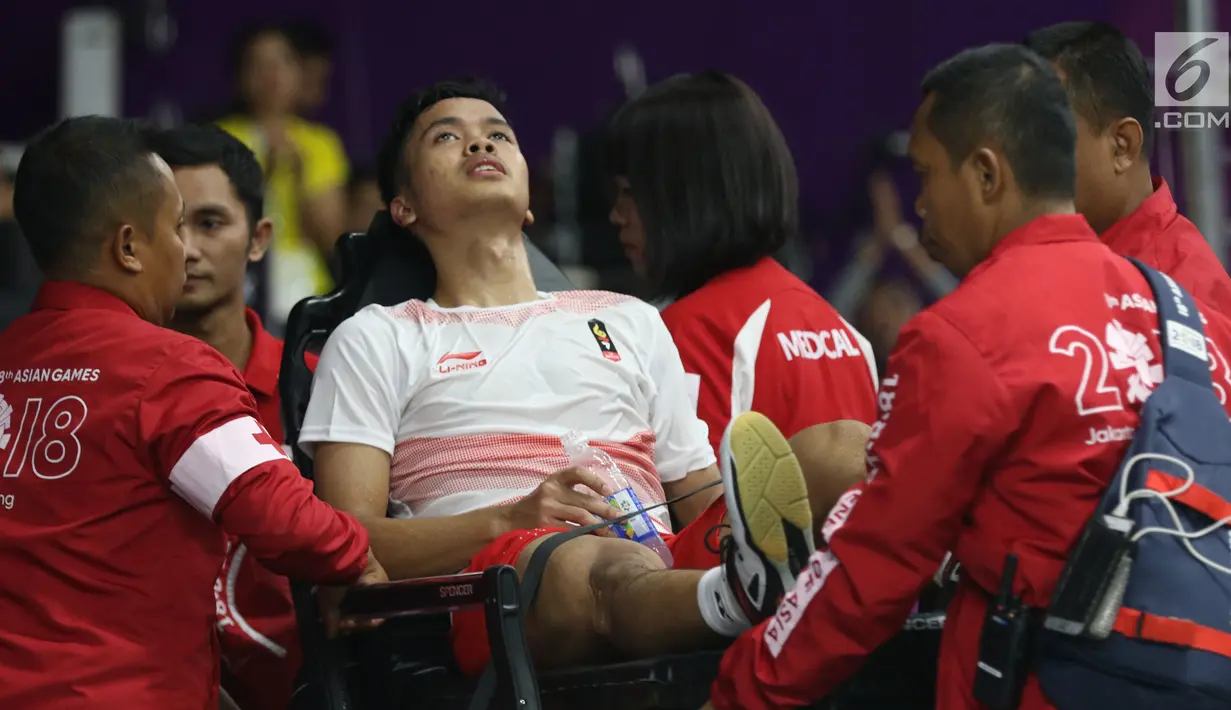Tunggal putra Indonesia, Anthony Sinisuka Ginting dievakuasi akibat cedera usai melawan pemain China, Shi Yuqi pada final Beregu Putra Asian Games 2018 di Istora Kompleks GBK, Jakarta, Rabu (22/8). Indonesia kalah 1-3. (Liputan6.com/Helmi Fithriansyah)