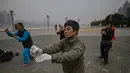 Orang-orang berlatih tai chi di pagi hari di sebelah Sungai Yangtze di Wuhan (20/11/2020). Dari total 50.340 kasus yang positif di Wuhan, 3.869 orang telah meninggal dunia akibat Covid-19 dan yang sembuh 46.471 orang. (AFP/Hector Retamal)