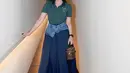 Ia tampil dalam balutan atasan hijau gelap dengan detail minimalis yang dipadukan dengan rok midi denim. Sentuhan unik terlihat dari aksen denim yang membingkai pinggangnya, memberikan kesan modern sekaligus santai. Rambutnya yang tertata rapi dengan headband menambahkan nuansa feminin pada penampilannya. [@ashanty_ash].