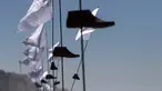 Sejumlah cetakan kayu sepatu dengan bendera putih yang merupakan seni instalasi di pajang di Playas de Tijuana, Meksiko (7/10). Seni instalasi yang bercerita tentang migran Meksiko ini adalah karya seniman Betsabee Romero. (AFP Photo/Guillermo Arias)