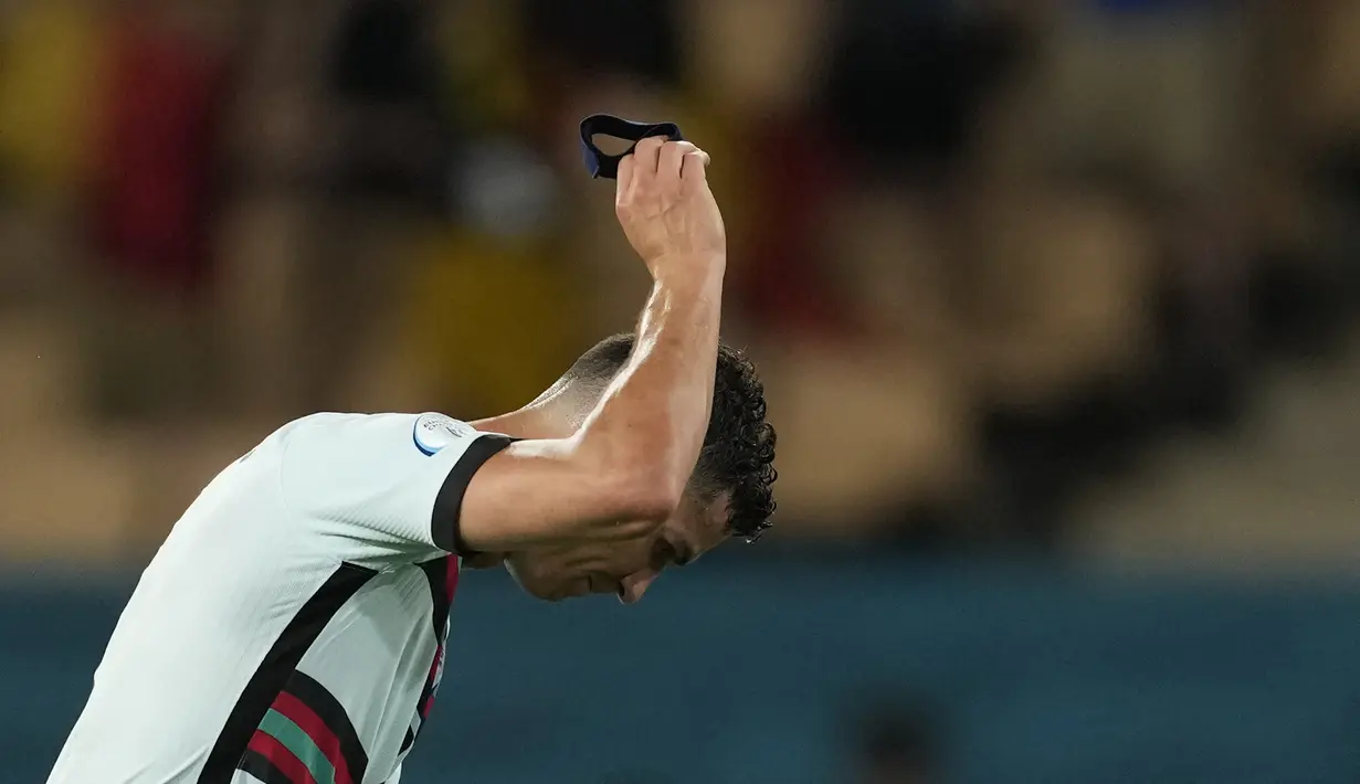 Reaksi kapten timnas Portugal, Cristiano Ronaldo pada akhir babak 16 besar Euro 2020 menghadapi Belgia di Estadio La Cartuja, Sevilla, Spanyol, Senin (28/6/2021) dini hari WIB. Cristiano Ronaldo membuang dan menendang ban kapten usai kalah dari Belgia 0-1. (THANASSIS STAVRAKIS/POOL/AFP)