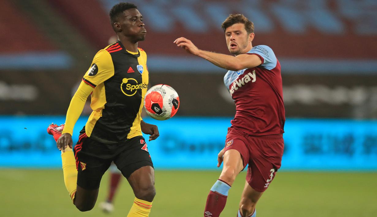 Bek West Ham United, Aaron Cresswell, berebut bola dengan gelandang Watford, Ismaila Sarr, pada laga lanjutan Premier League pekan ke-36 di London Stadium, Sabtu (18/7/2020) dini hari WIB. West Ham menang 3-1 atas Watford. (AFP/Adam Davy/pool)