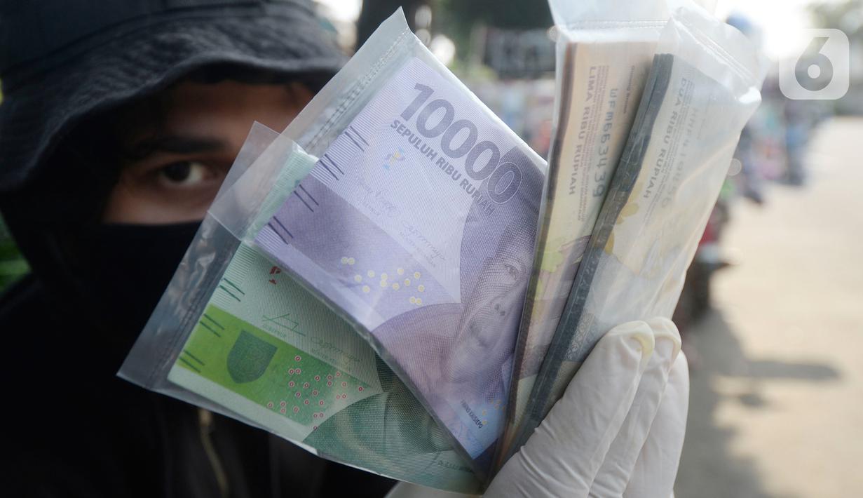 Penjual jasa penukaran uang menawarkan uang baru berbagai pecahan kepada pengguna jalan di kawasan Bintaro Sektor 2, Jakarta Selatan, Selasa (12/05/2020). Menjelang perayaan Lebaran, jasa penukar uang keliling yang berada di pinggir jalan-jalan utama mulai bermunculan. (merdeka.com/Dwi Narwoko)