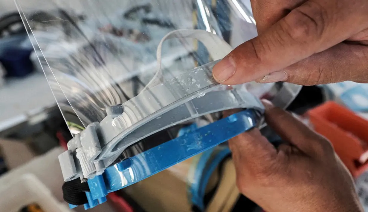 Pelindung wajah yang terbuat dari kombinasi plastik dan tekstil ditunjukkan di perusahaan Plaxtil, Chatellerault, Prancis, 25 Agustus 2020. Startup di Prancis, Plaxtil, mendaur ulang masker dan plastik untuk dijadikan pelindung wajah, pembuka pintu, dan pengencang masker. (GUILLAUME SOUVANT/AFP)
