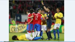 Wasit Ecuador Roddy Zambrano memberikan kartu kuning kepada pemain Chile Marcelo Diaz (kiri) pada laga kualifikasi Piala Dunia 2018 di Santiago, Chile, Kamis (08/10/2015). Chile menang 2-0. (AFP Photo/Claudio Reyes)