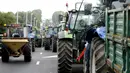 Sejumlah peternak sapi perah menaiki traktor mereka menuju jalan tol atau jalan bebas hambatan untuk melakukan aksi protes di Battice, Belgia, Kamis (30/7/2015). Aksi protes tersebut berkaitan dengan rendahnya harga jual susu. (REUTERS/Francois Lenoir)