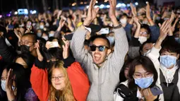 Orang-orang bereaksi saat sebuah band tampil pada Festival Musik Rye yang digelar selama dua hari di Beijing pada 18 Oktober 2020. (Photo by Noel Celis / AFP)