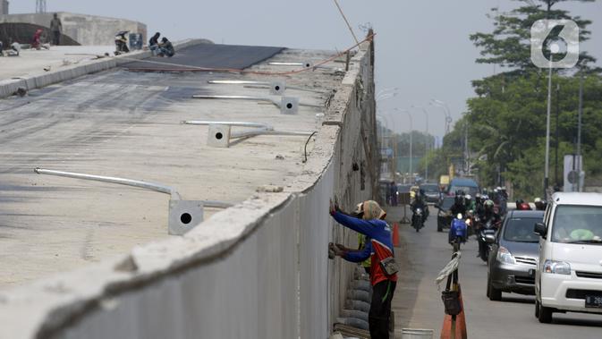 Pekerja menyelesaikan proyek pembangunan jembatan layang perempatan Pondok Cabe, Tangerang Selatan, Banten, Rabu (15/4/2020). Pembangunan jembatan layang tersebut untuk mengurai kemacetan di lampu merah dari Jakarta ke Bogor dan dari Pondok Cabe ke Kota Tangerang Selatan. (merdeka.com/Dwi Narwoko)