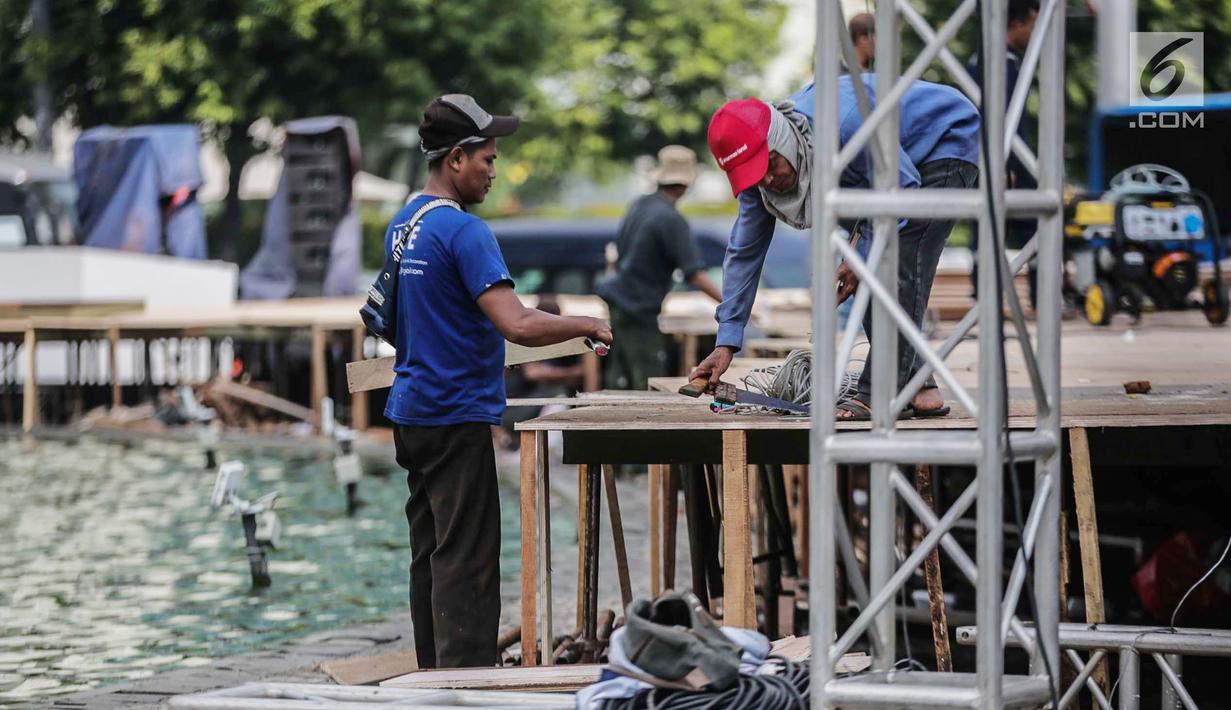 Pekerja menyelesaikan pembuatan panggung HUT ke-492 DKI di area Bundaran HI, Jakarta, Kamis (20/6/2019). Pemprov DKI Jakarta akan menggelar pesta rakyat di area Bundaran HI pada 22 Juni 2019. (Liputan6.com/Faizal Fanani)
