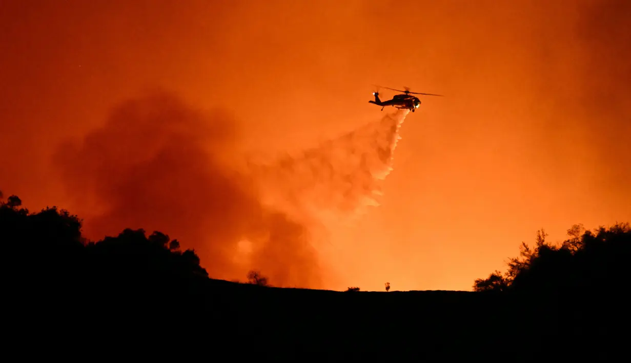Pemadaman api juga dilakukan melalui udara dengan mengerahkan helikopter. (Patrick T. Fallon/AFP)