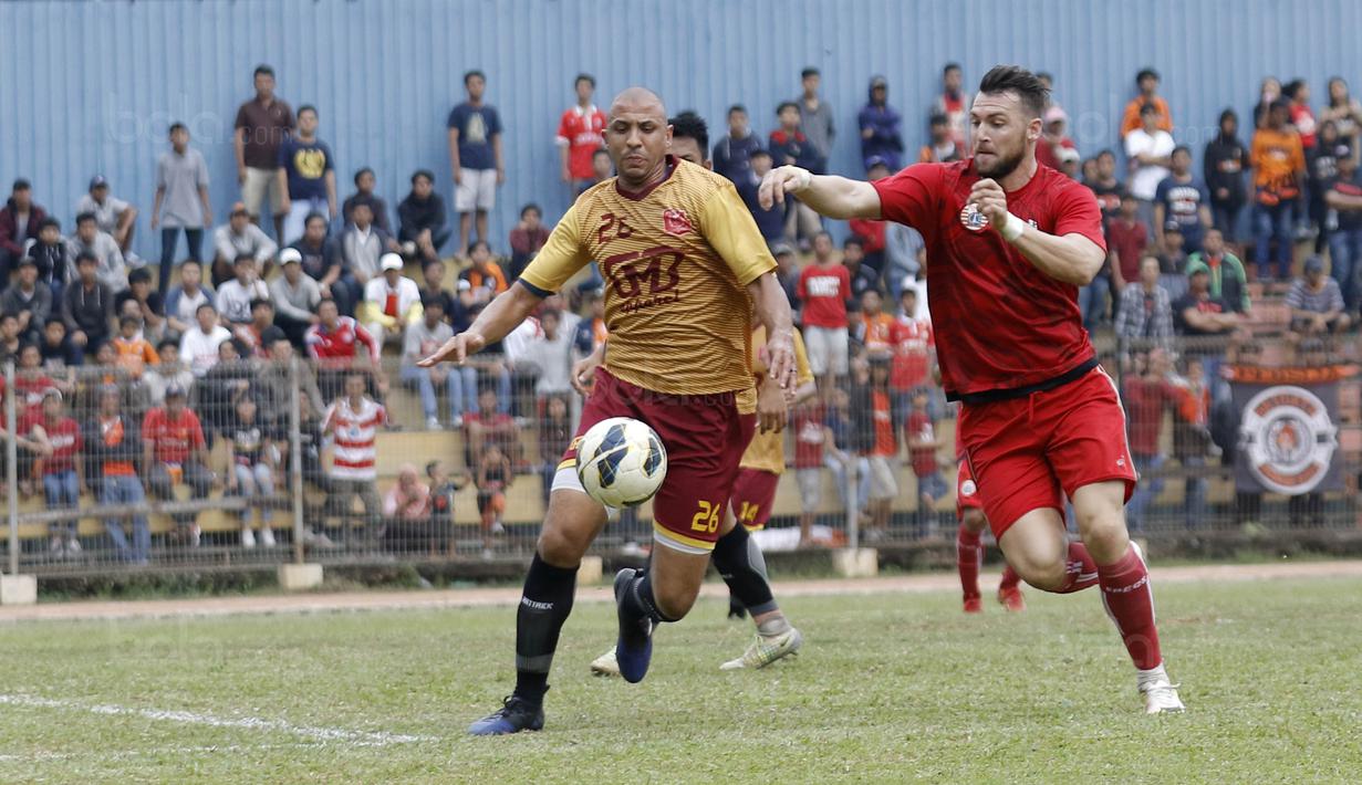 Striker Persija, Marko Simic, berebut bola dengan pemain Persika Karawang pada laga uji coba di Stadion Soemantri Brodjonegoro, Kuningan, Jakarta, Sabtu (30/12/2017). Persija menang 3-1 atas Persika. (Bola.com/M Iqbal Ichsan)