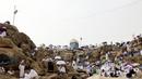 Jemaah haji berkumpul di sekitar Jabal al-Rahma (Gunung Rahmat) saat menunaikan prosesi wukuf di Padang Arafah, tenggara Kota Suci Mekah, Arab Saudi, Senin (19/7/2021). Wukuf di Padang Arafah dua tahun terakhir berada dalam pembatasan karena pandemi corona virus COVID-19. (FAYEZ NURELDINE/AFP)