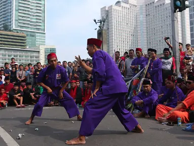 Para pendekar Betawi menunjukan aksi beladiri khas Betawi di Jakarta, Minggu (7/8). Sekitar 1000 pendekar memadati Bundaran HI untuk merayakan Lebaran Pendekar Betawi 2016. (Liputan6.com/Angga Yuniar)